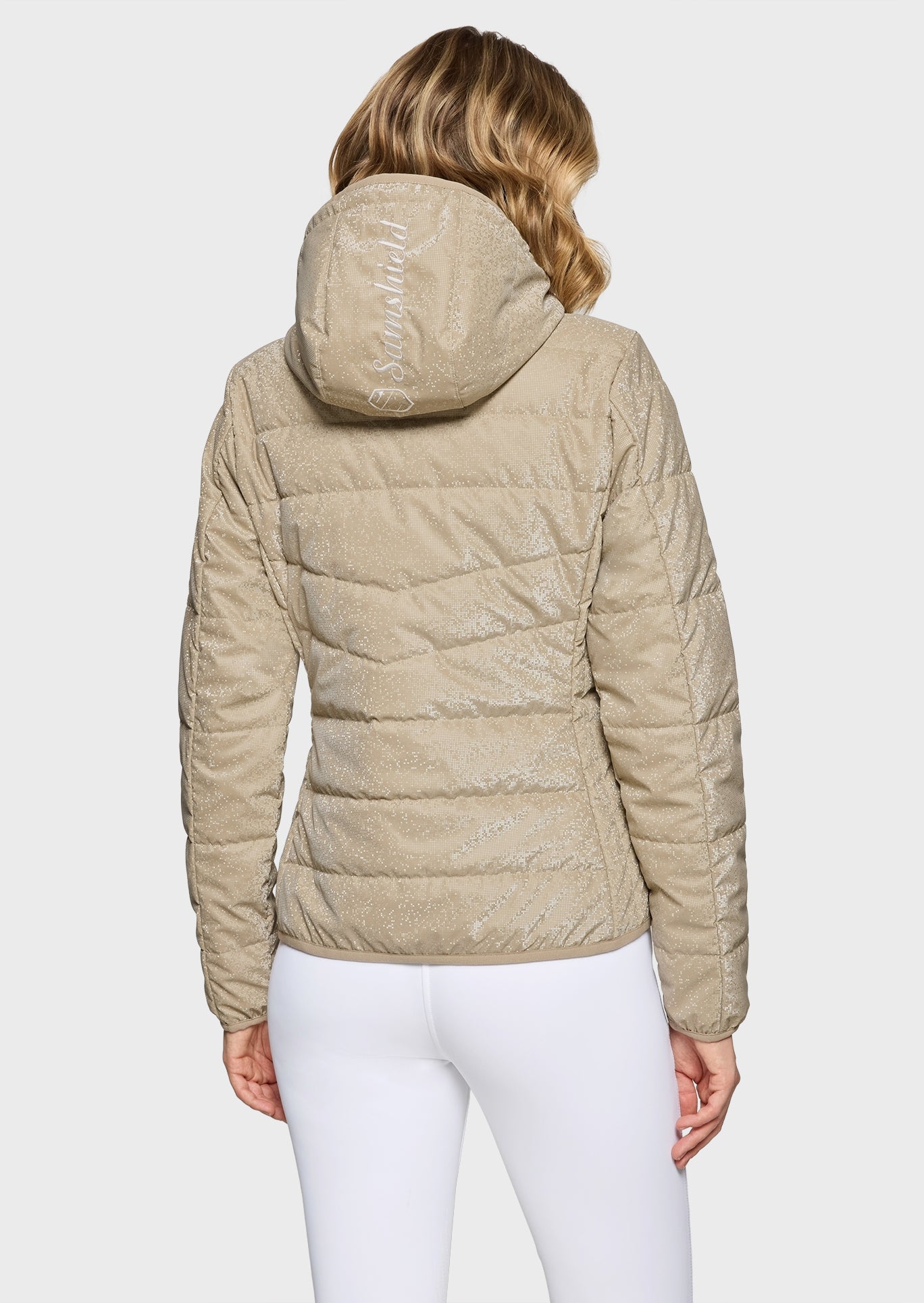 Beige quilted jacket worn by a person on a white background