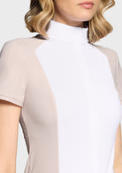 Close-up of a woman wearing a beige and white dress with sheer sleeves.