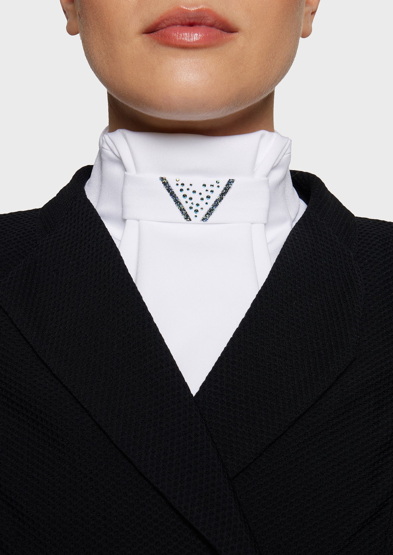Close-up of a person wearing a black blazer and white shirt with a patterned collar.