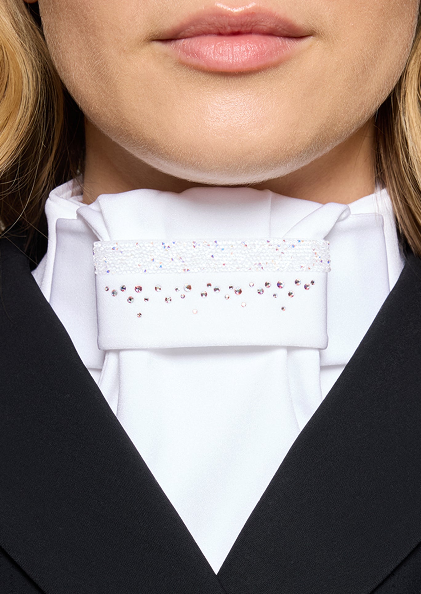 Close-up of a person wearing a white shirt with a decorative collar and black jacket.