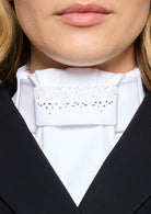 Close-up of a person wearing a white shirt with a decorative collar and black jacket.