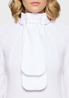 Close-up of a person wearing a white outfit with a decorative collar on a light background