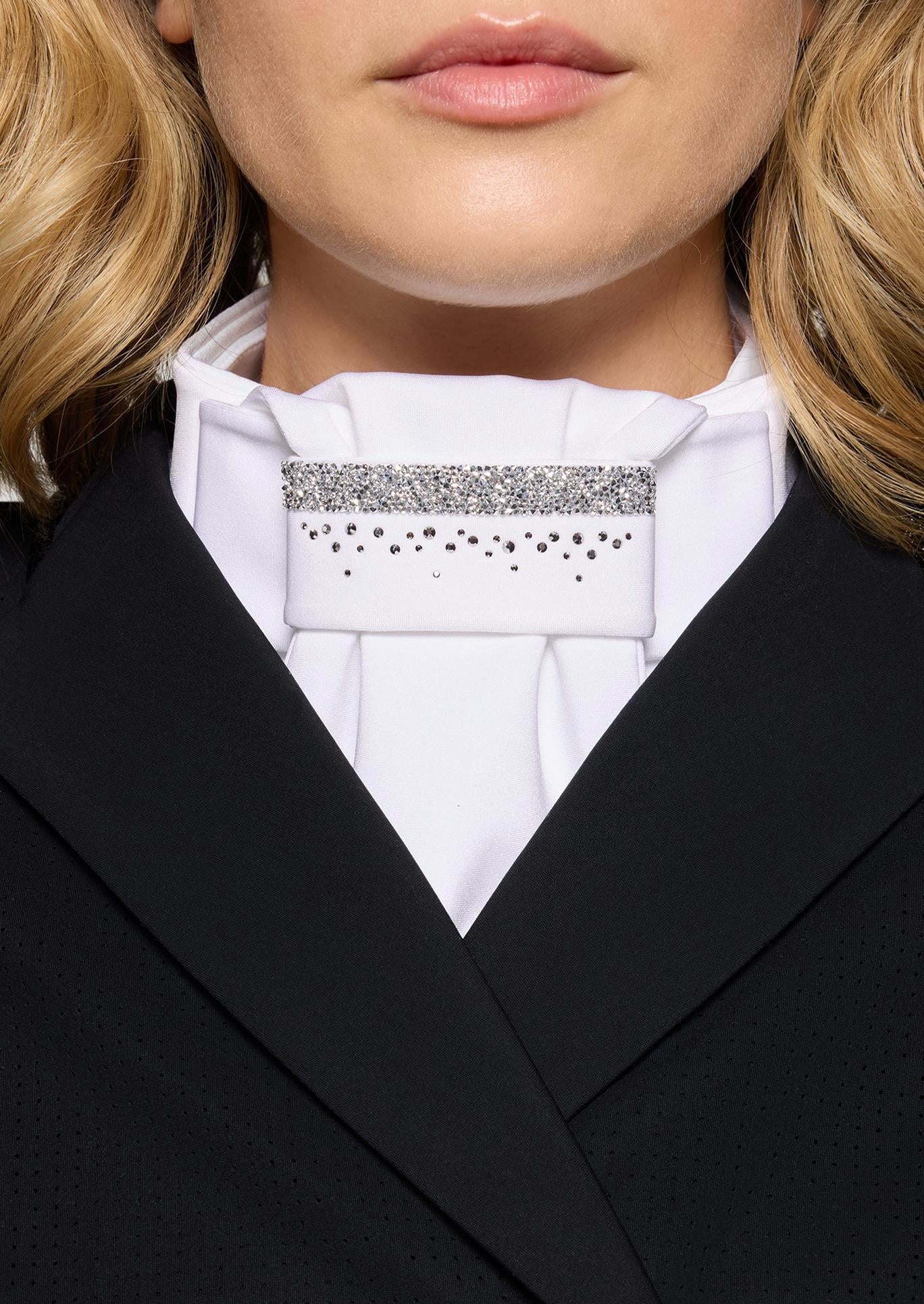 Close-up of a person wearing a black blazer and white shirt with a decorative collar.