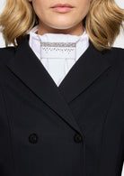 Close-up of a person wearing a black coat over a white shirt with lace details.