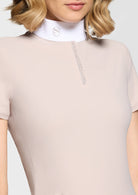 Beige equestrian jumpsuit with a white collar and brand logo on a plain background