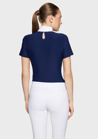 Woman wearing a navy blue top with a cut-out back design on a white background