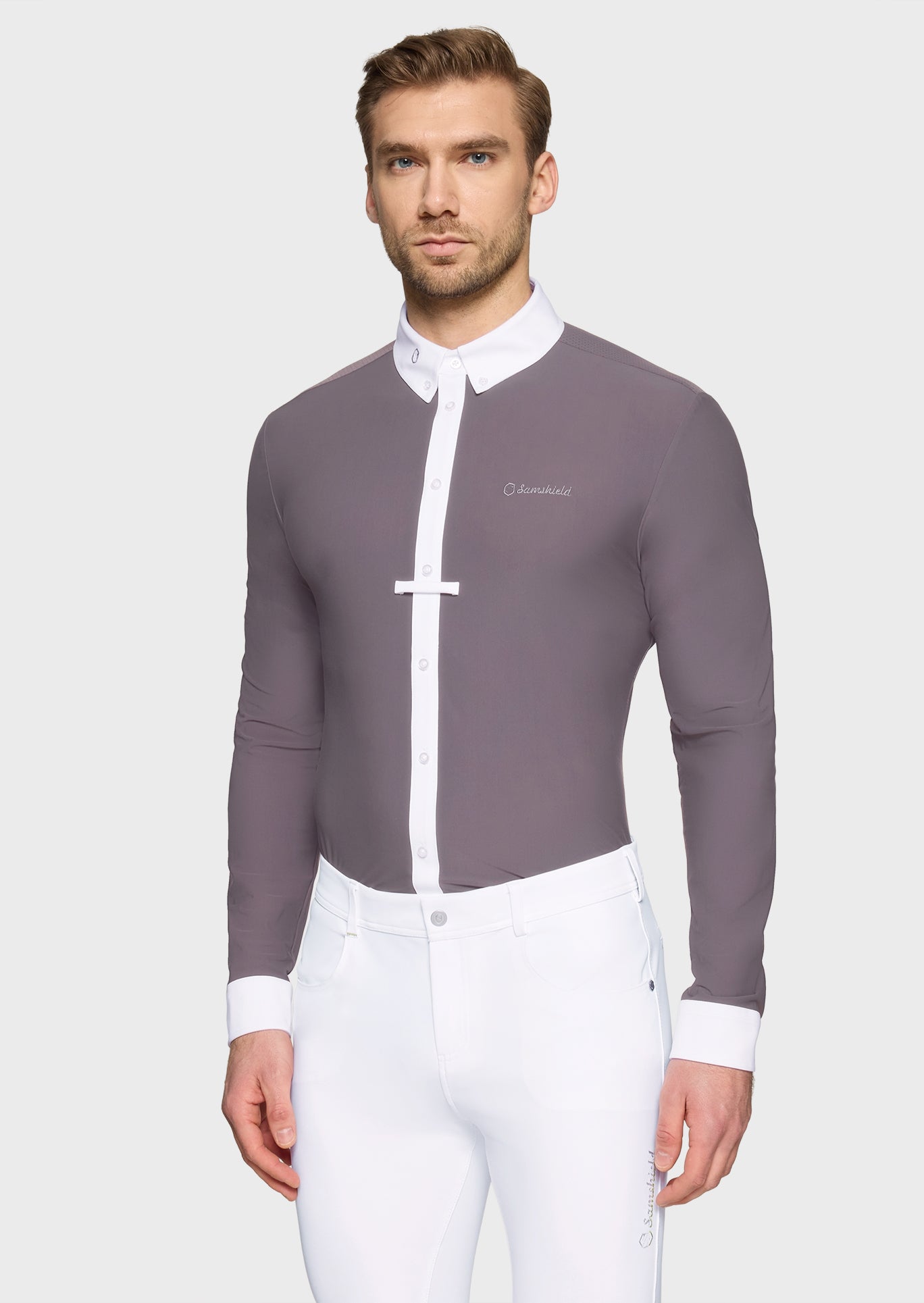 Man wearing a gray equestrian shirt with white collar and trim on a light gray background