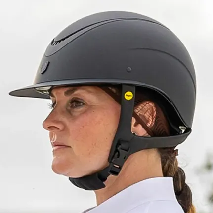 Person wearing a dark gray helmet with a visible brand logo on a blurred background