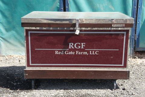 A red storage box labeled 'RGF Red Gate Farm, LLC' with a lock on the front.