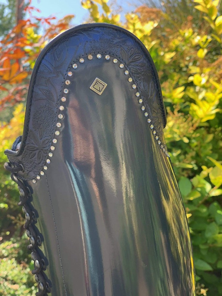 DETAIL VIEW OF NAVY GRETA AND CRYSTAL ACCENTS ON NAVY BRUSHED LEATHER DENIRO BOTTICELLI DRESSAGE BOOT WITH FRONT POLO LACES