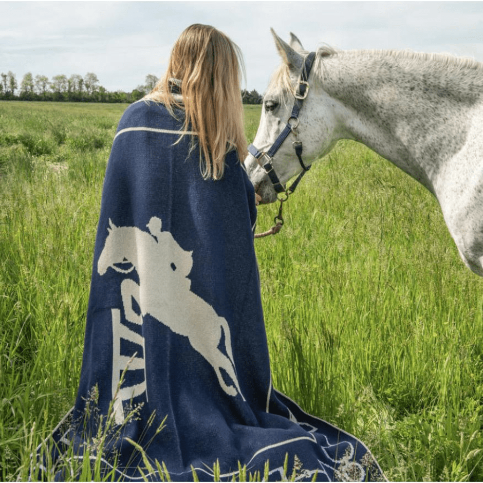 In2green marine hunter jumper throw draped over a model leading a horse. 